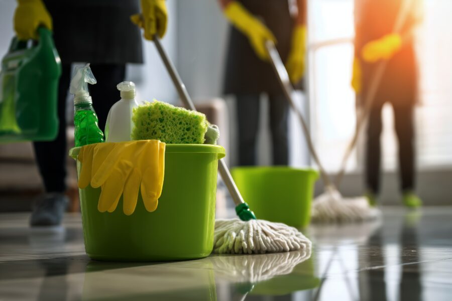 Care home cleaning team with mops, gloves, and cleaning supplies during routine cleaning