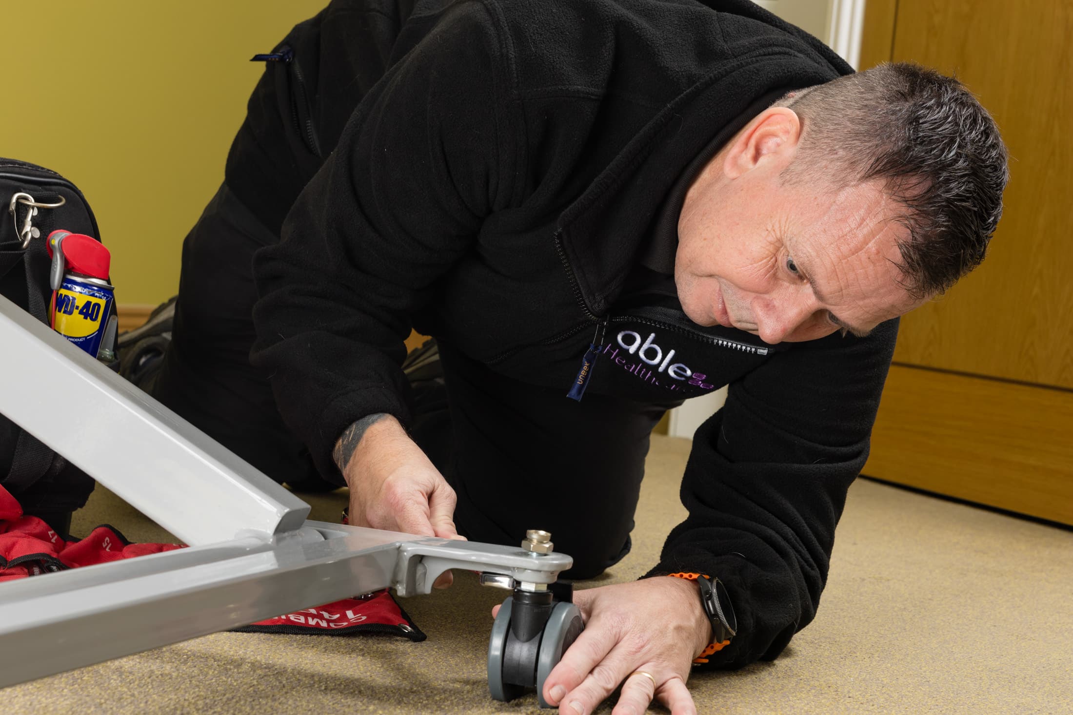 PUWER inspection in a care home with engineer checking a profile bed for safety and compliance