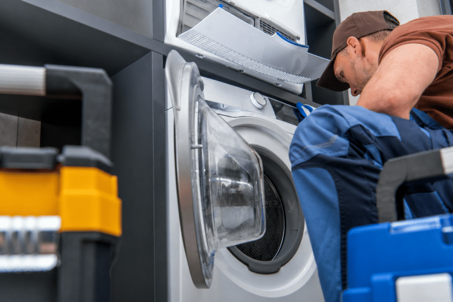 Commercial laundry equipment installation engineer servicing a commercial washing machine